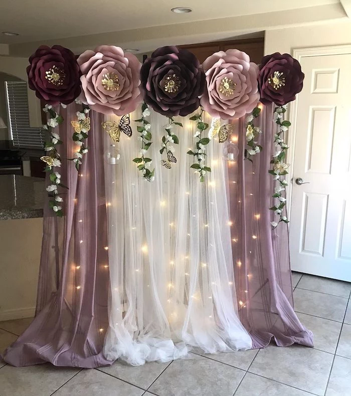 white and purple tulle with fairy lights, giant purple and pink paper flowers on top, diy tissue paper flowers