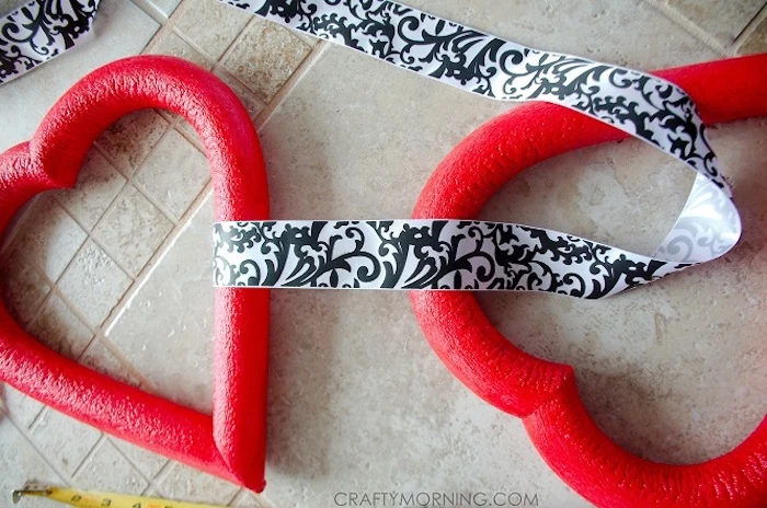 two red foam hearts, tied together with black and white satin ribbon, heart decorations, step by step diy tutorial