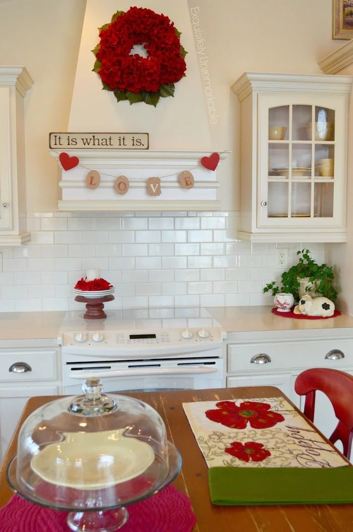 valentine's day home decor, red wreath hanging in the kitchen, love banner, it is what it is sign, kitchen in white