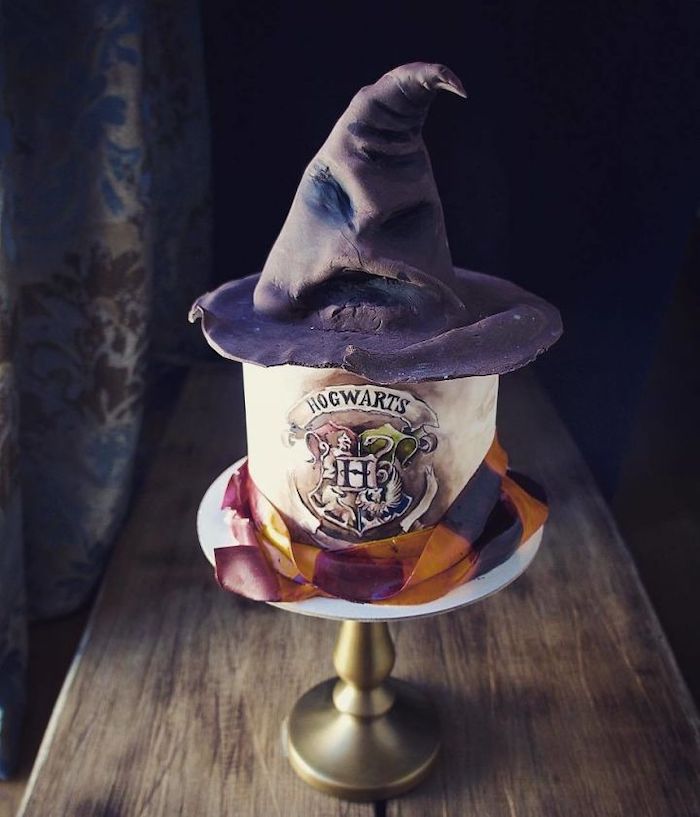 hogwarts cake made with fondant, easy harry potter cake, gryffindor scarf around it, sorting hat on top