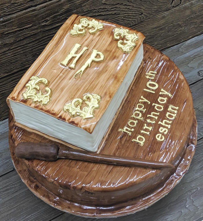 harry potter birthday cake hagrid, two tier cake, top tier in the shape of book, wand made of fondant on bottom layer