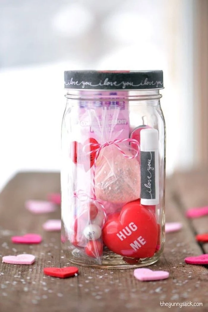 mason jar filled with different things, placed on wooden surface, valentines day gifts, conversation hearts and lip balm