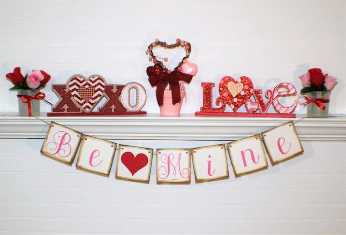 valentines home decor, be mine banner, hanging over white mantel, xoxo and love signs on top, small roses bouquets