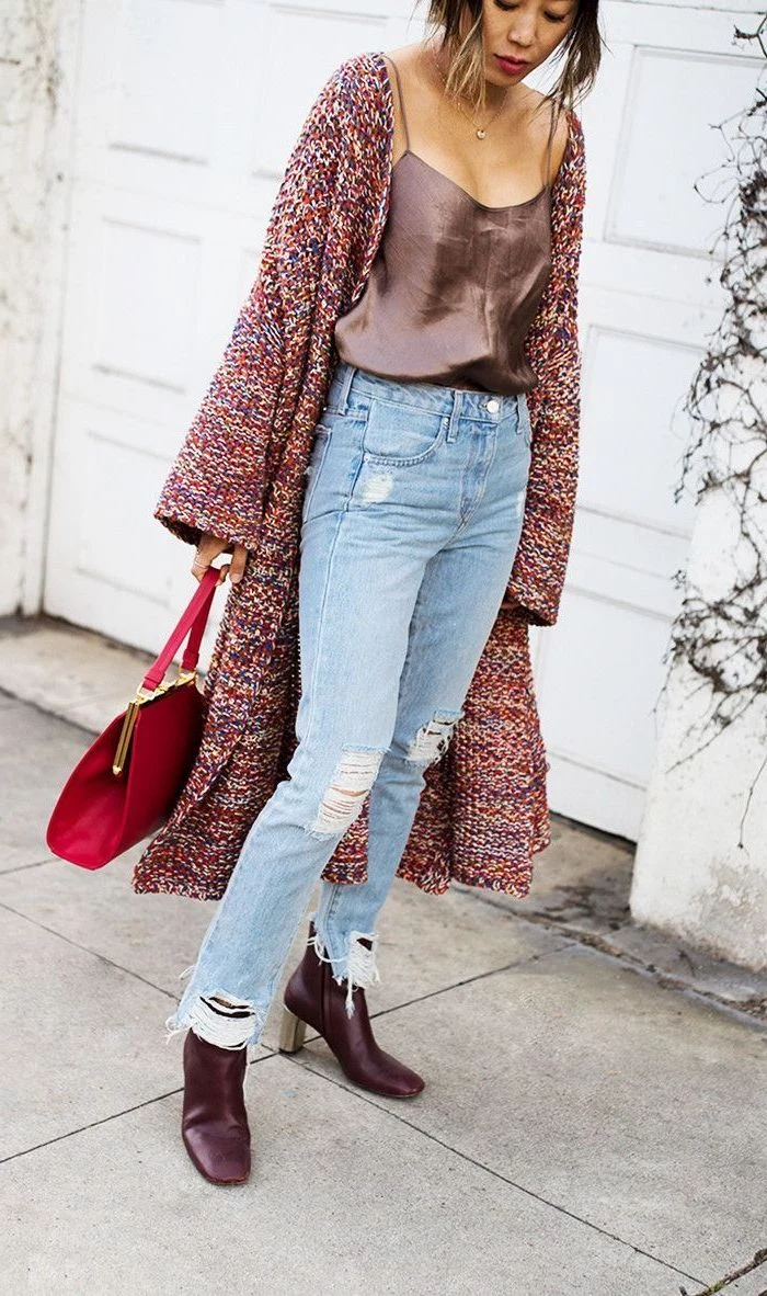 woman wearing brown top and jeans, long colorful knitted cardigan, valentines day outfit girl, red bag and burgundy boots