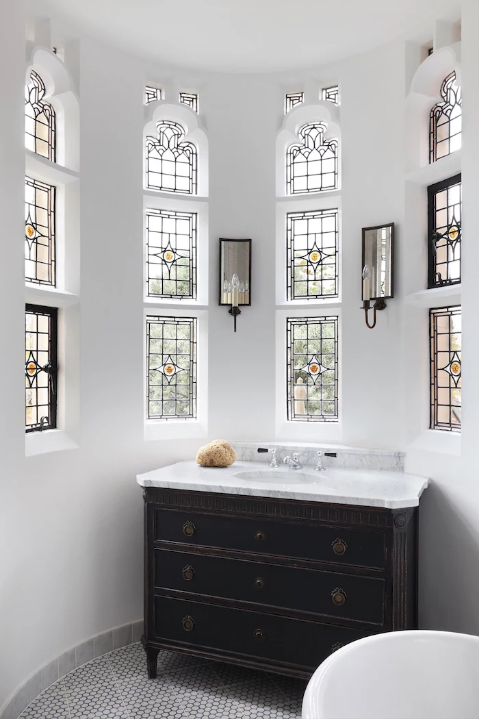 bathroom with white walls, dark wooden cupboard, marble countertop sink, how to make stained glass windows, tall and narrow windows