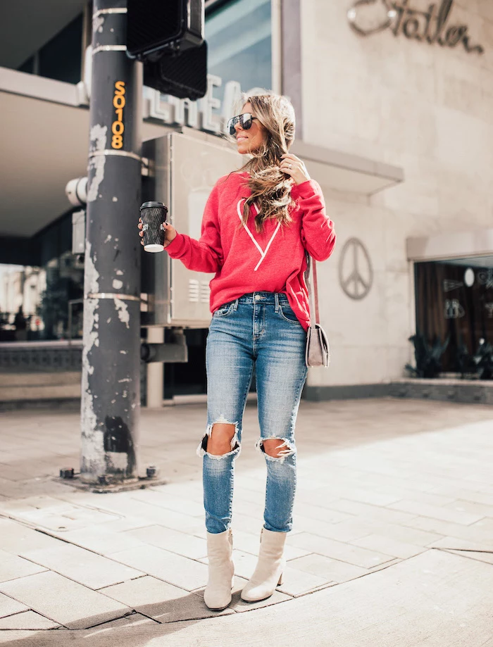 blonde woman wearing jeans and red blouse, cute valentines day outfits, white leather boots, holding coffee cup