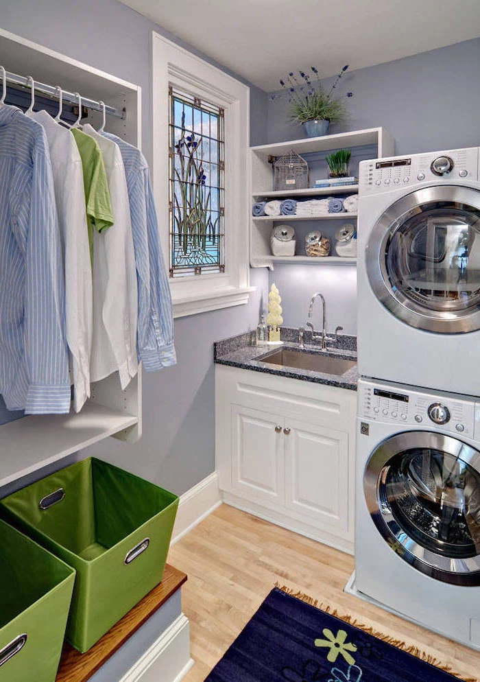 laundry room with wooden floor, custom stained glass windows, washing and drying machines, small window above the sink