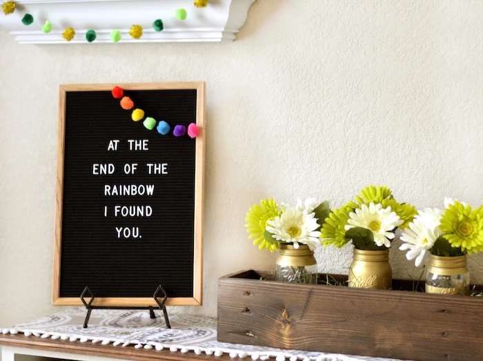at the end of the rainbow i found you sign, rainbow pom poms garland on it, st patrick's day decorations, flower bouqets