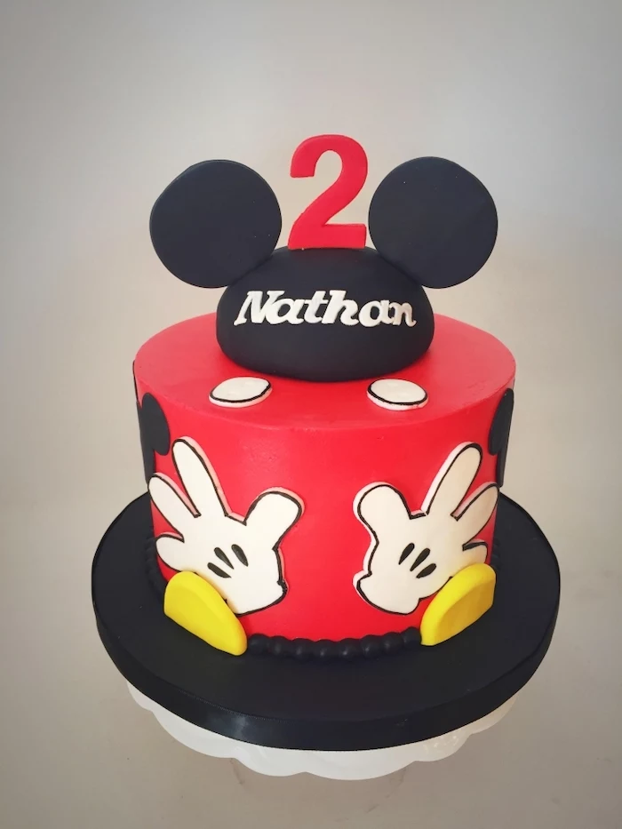 one tier cake, covered with red and black fondant, mickey mouse clubhouse cake, placed on black and white cake stand