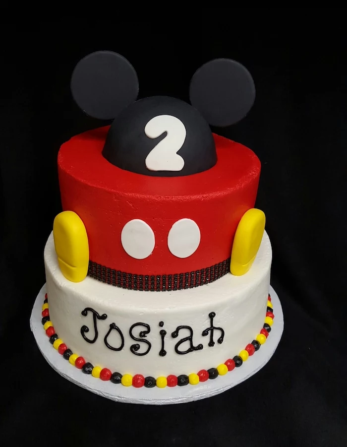 two tier cake, covered with black red and white fondant, decorated with fondant, celebration cakes, placed on white tray