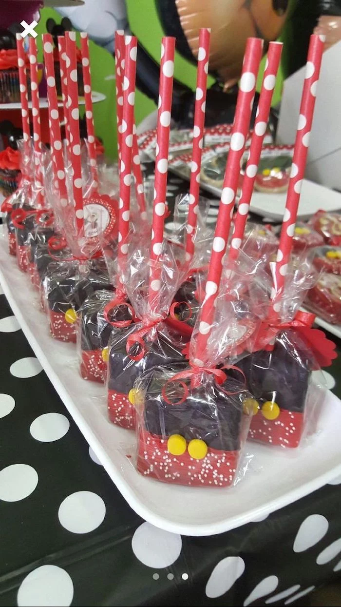 cake pops wrapped in cellophane, mickey mouse 1st birthday cake, made with chocolate, arranged on white plate