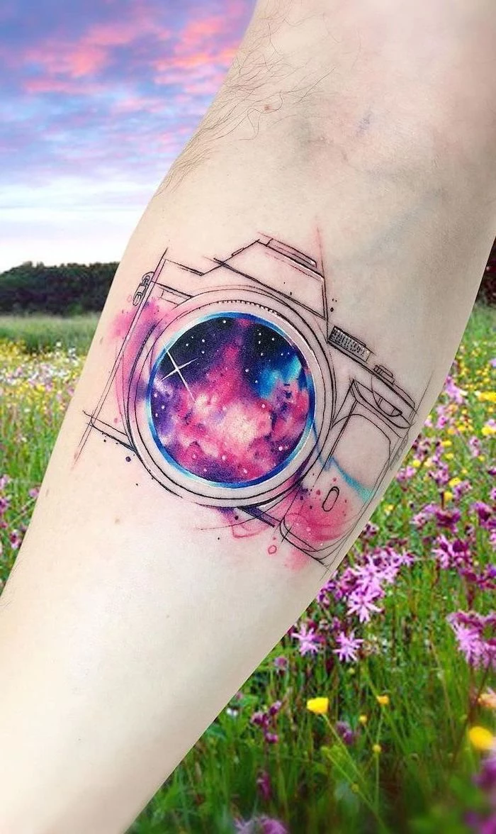 photo camera forearm tattoo, camera lens with galaxy inside, universe tattoo, black purple and pink colors