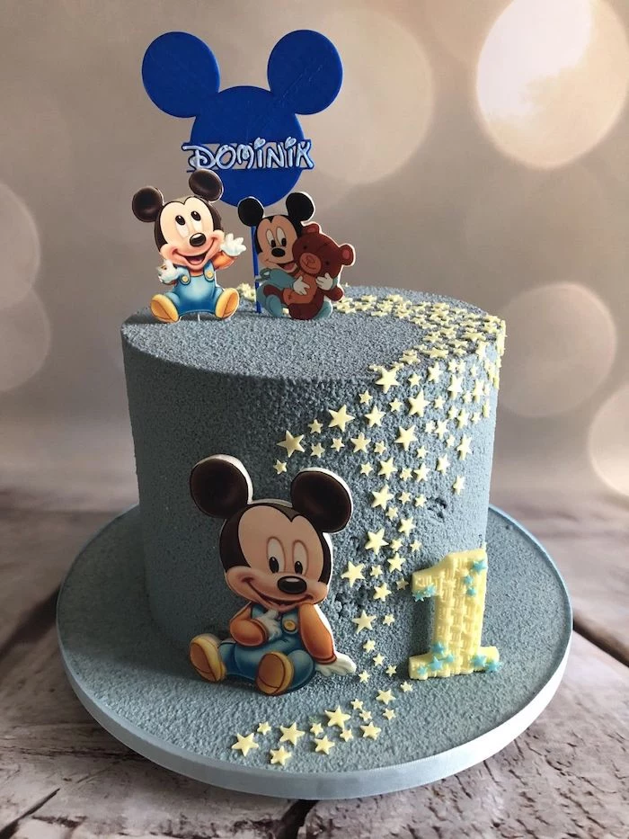 one tier cake, covered with dark grey buttercream, yellow fondant stars, mickey mouse birthday cake, mickey cake toppers