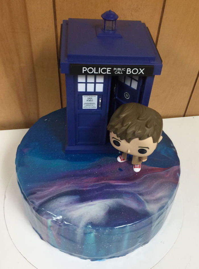 doctor who one tier galaxy cake, two tier cake, police box and doctor who funko head on top, placed on white cake tray