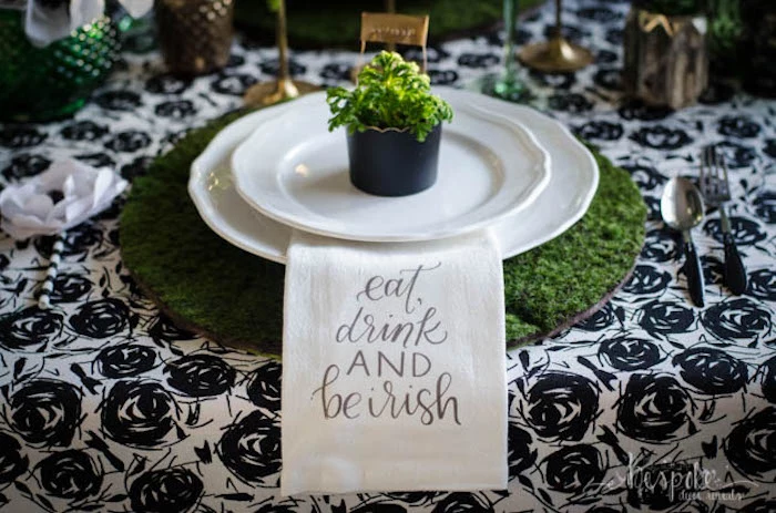 eat drink and be irish napkin, st patrick's day wreath, moss place mat, two white plates, small plant on them