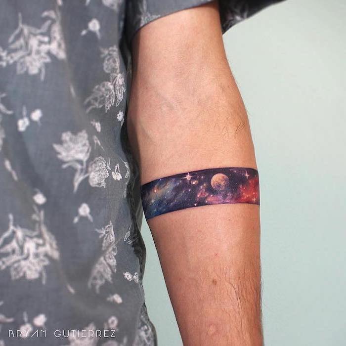 armband forearm tattoo, outer space tattoo, blue purple and orange galaxy with stars and planet