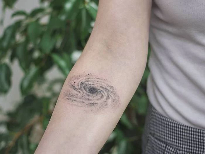 milky way galaxy, forearm tattoo, outer space tattoo, woman wearing grey top