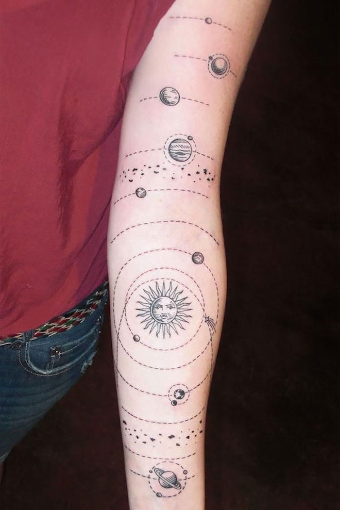 sun with planets orbiting around it, tattoo on the whole arm, universe tattoo, woman wearing red top and jeans