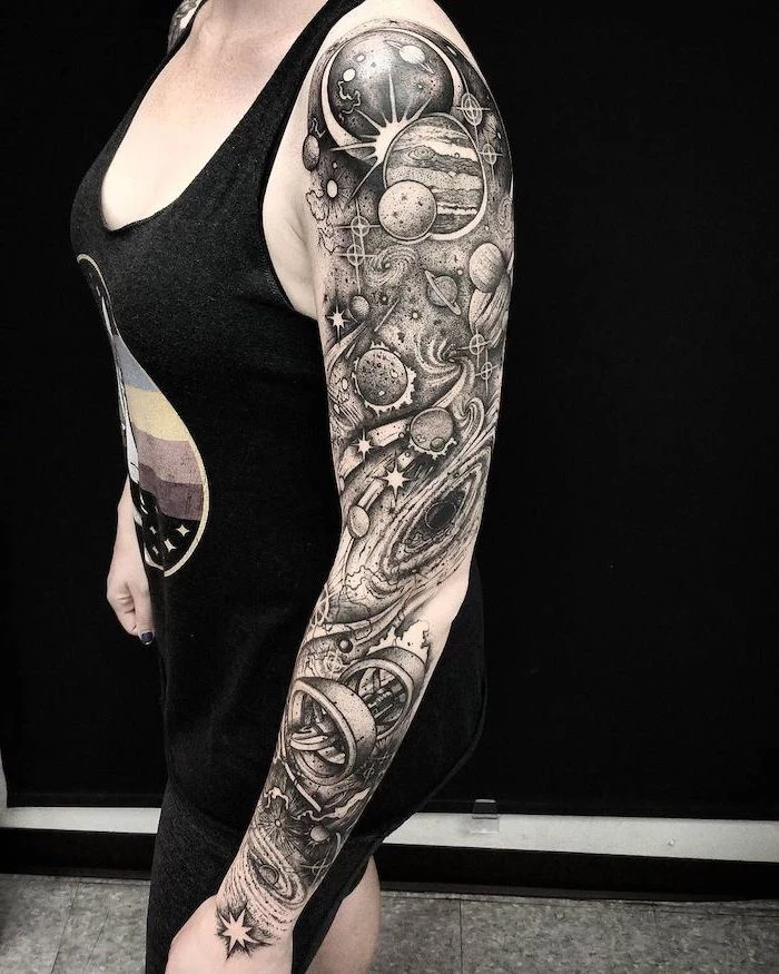 whole sleeve tattoo, planets galaxies and stars, woman wearing black top and pants, galaxy tattoo sleeve