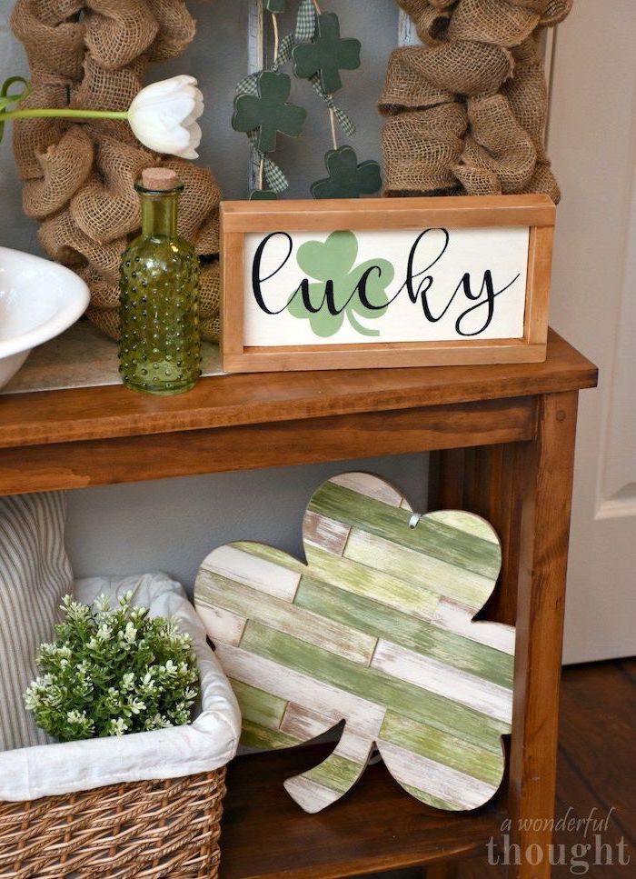 green and white wooden shamrock, placed on wooden shelf, lucky inside wooden frame on top shelf, happy st patrick's day