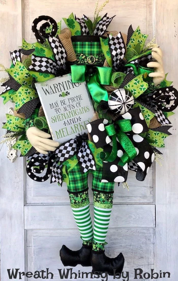 wreath made with different ribbons, green gold black and white, hanging on white wooden door, st patrick's day accessories
