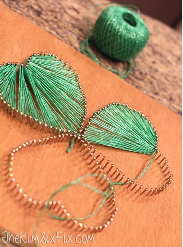 st patrick's day accessories, shamrock string art, step by step diy tutorial, green thread connecting nails on wooden block