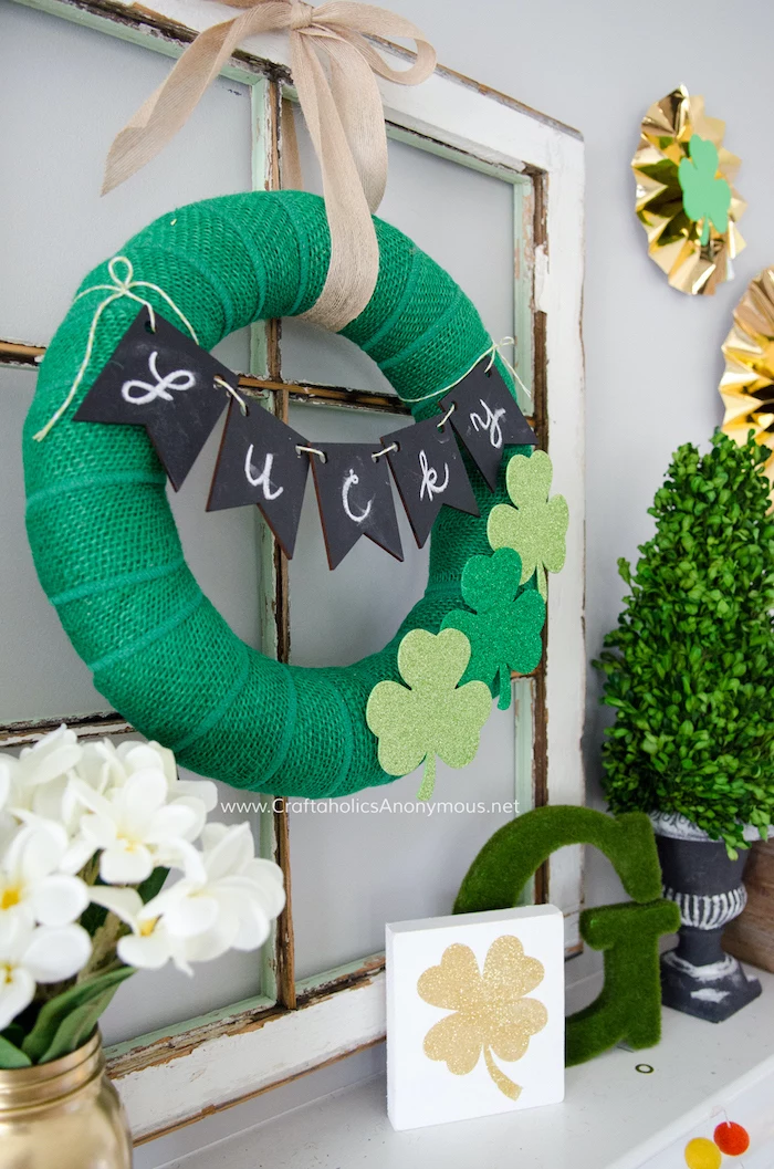 wreath covered with green tulle, happy st patrick's day, lucky garland across it, hanging on wooden window frame