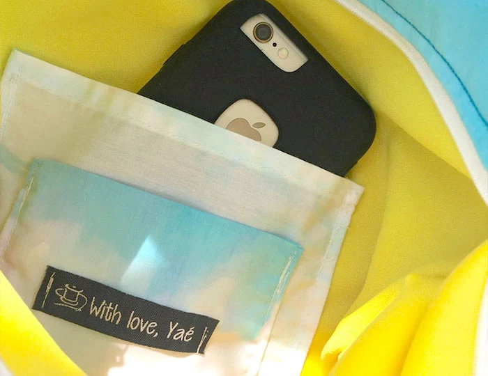 iphone placed inside a jacket pocket, yellow jacket with white pocket, clothing labels, with love yae