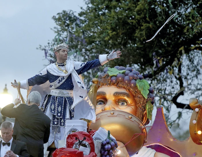 jensen ackles, supernatural actor, dressed as king bacchus, masquerade masks, throwing beads necklaces at the crowd