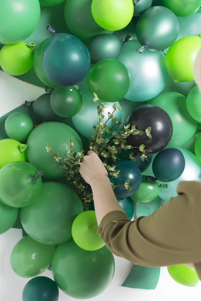 balloons in different shades of grey, arranged together, happy st patrick's day, faux greenery between the balloons