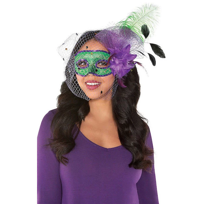 masquerade party masks, woman wearing purple blouse, green mask with purple decorations, green feathers and tulle