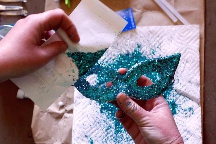 white mask covered with turquoise glitter, masquerade masks for couples, step by step diy tutorial