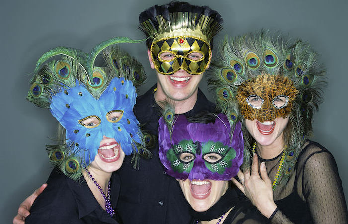 people smiling at the camera, posing for a photograph, what to wear to mardi gras, wearing different masks with feathers
