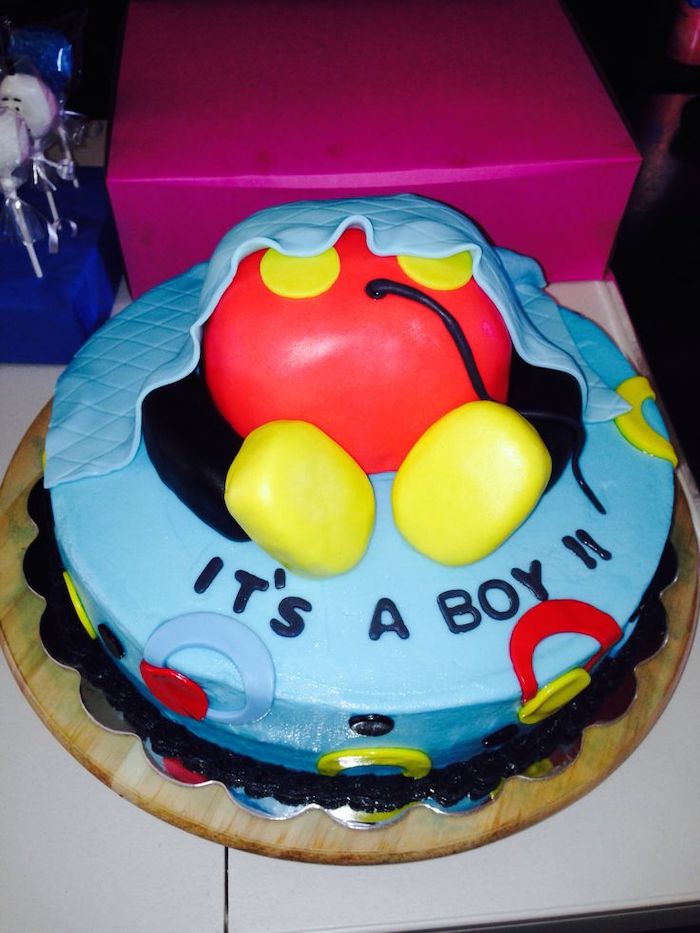 it's a boy, one tier cake, decorated with blue red and yellow fondant, mickey mouse cakes 1st birthday, placed on wooden tray
