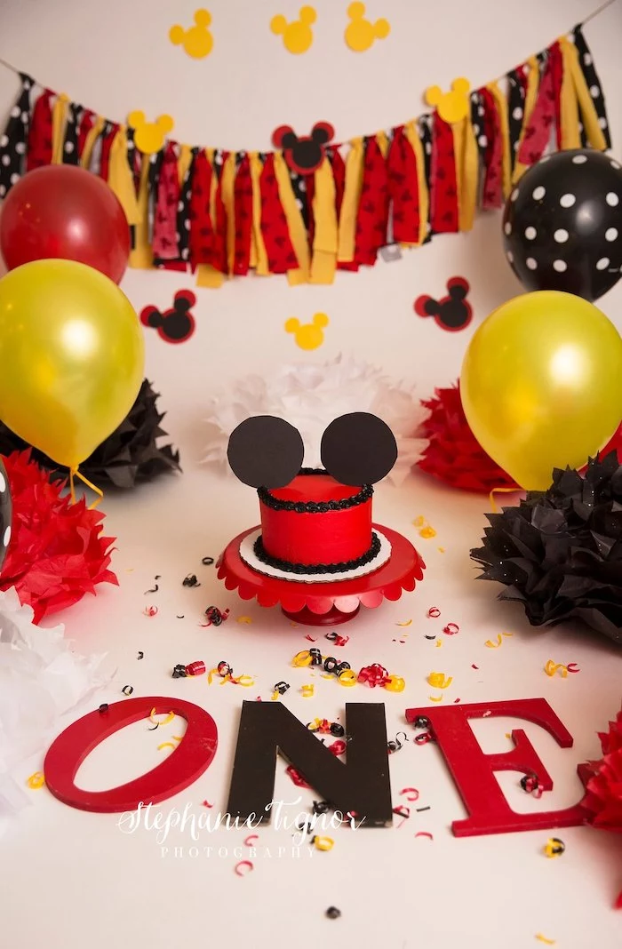 red yellow and black balloons, mickey cake, party decorations, cake in the middle, covered with red fondant