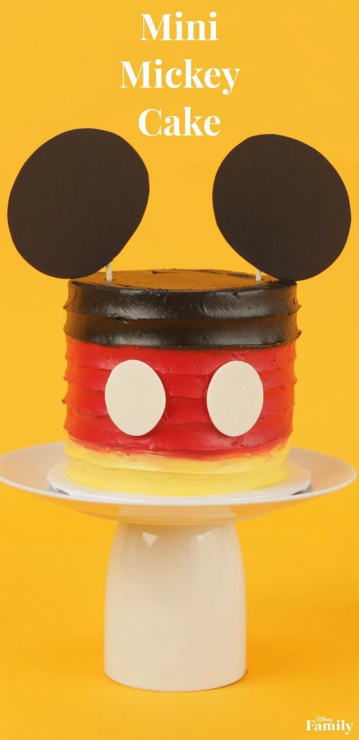 mickey mouse smash cake, mini mickey cake, decorated with brown red and yellow buttercream, placed on white cake stand