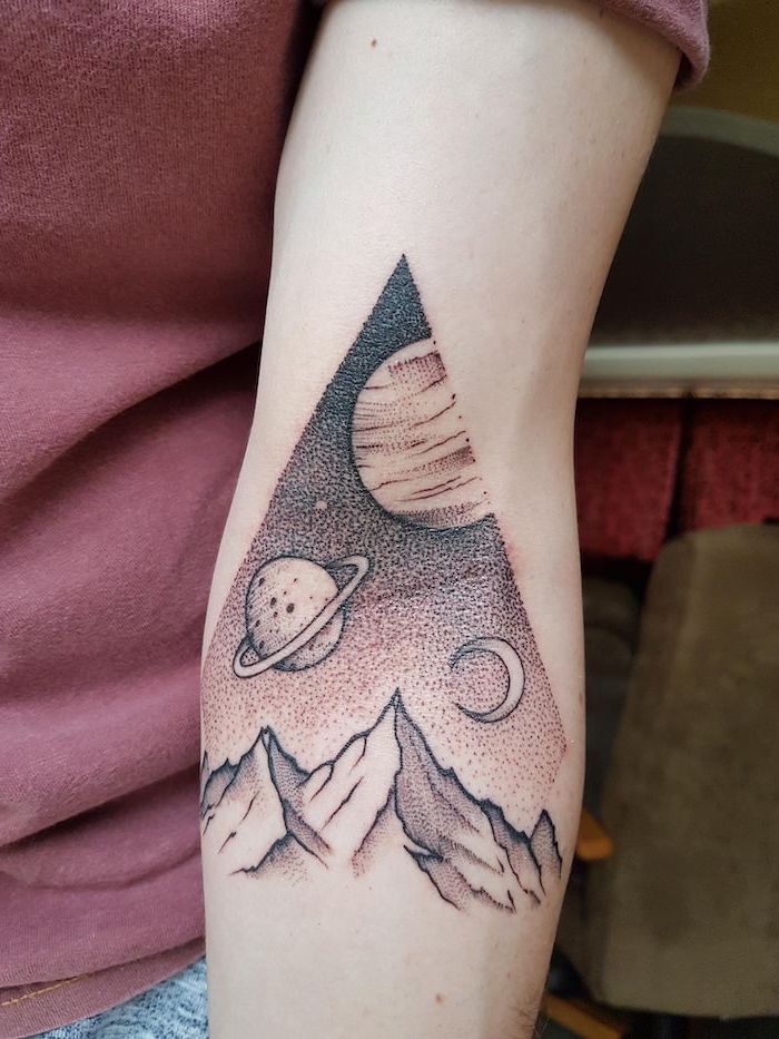 triangle geometrical forearm tattoo, small space tattoos, black and white tattoo, planets and stars above mountain landscape