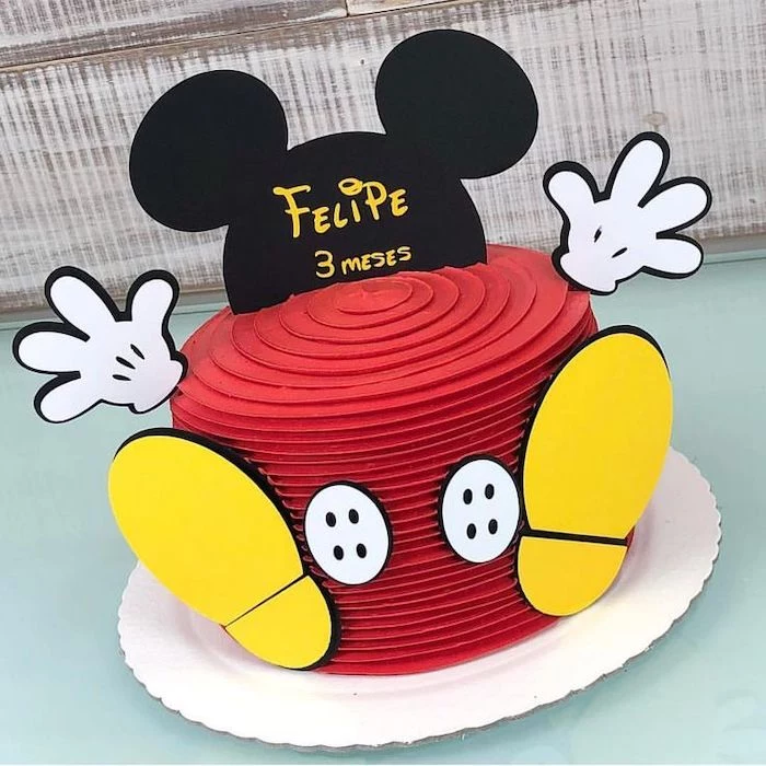 one tier cake, covered with red buttercream, mickey mouse smash cake, placed on white cake tray