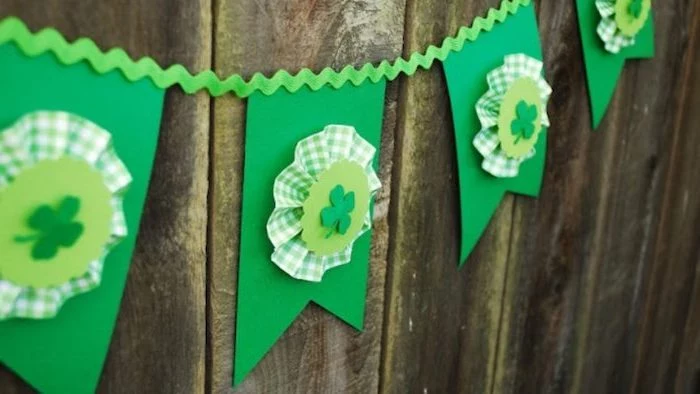 green paper garland with shamrocks, green and white fabric, st patricks decor, hanging on wooden wall