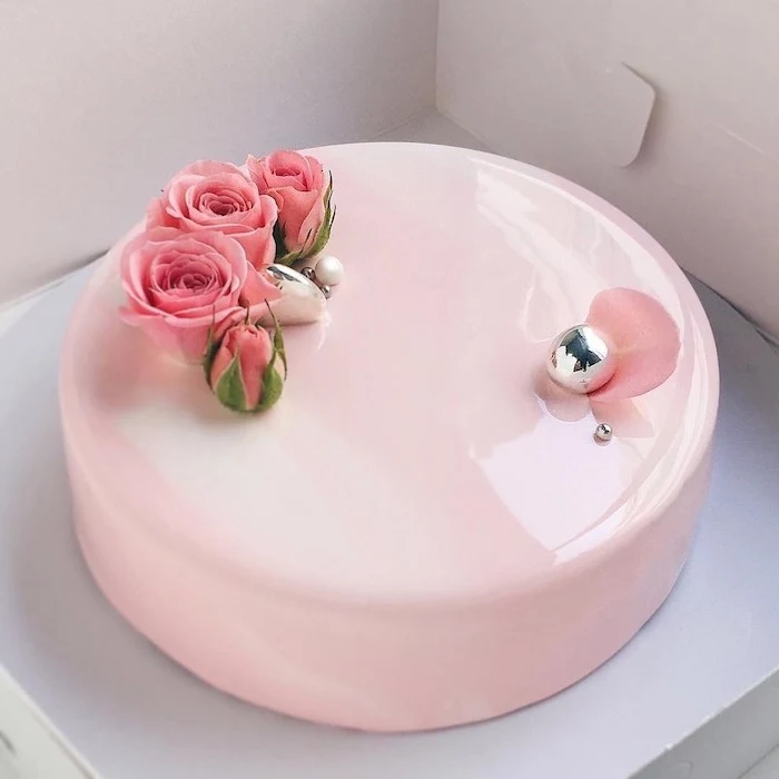 one tier cake with pink glaze, pink roses decorations on top, galaxy mirror cake, placed in white carton box