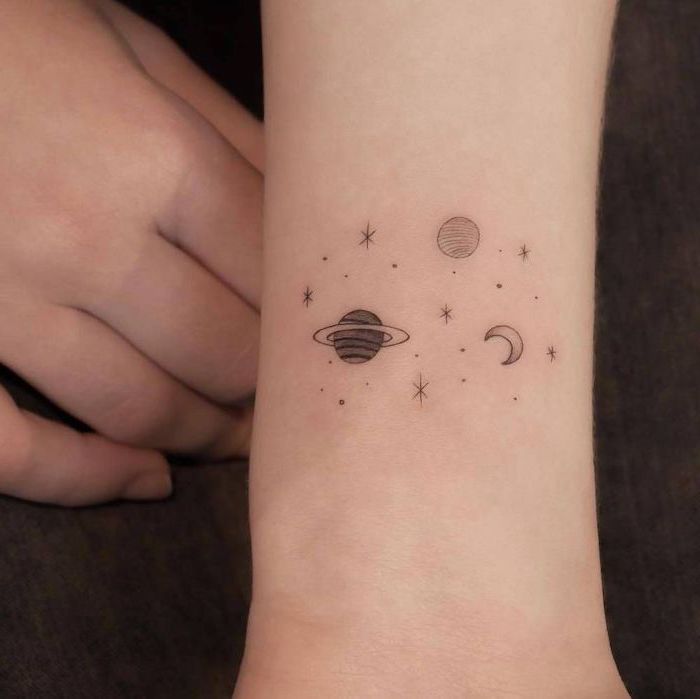 small wrist tattoo, space themed tattoos, planets stars and moon, black and white tattoo
