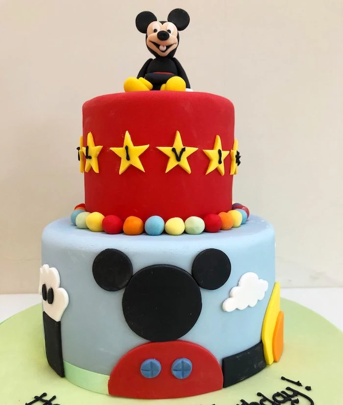 two tier cake, covered with red and blue fondant, mickey mouse cake pops, mickey cake topper