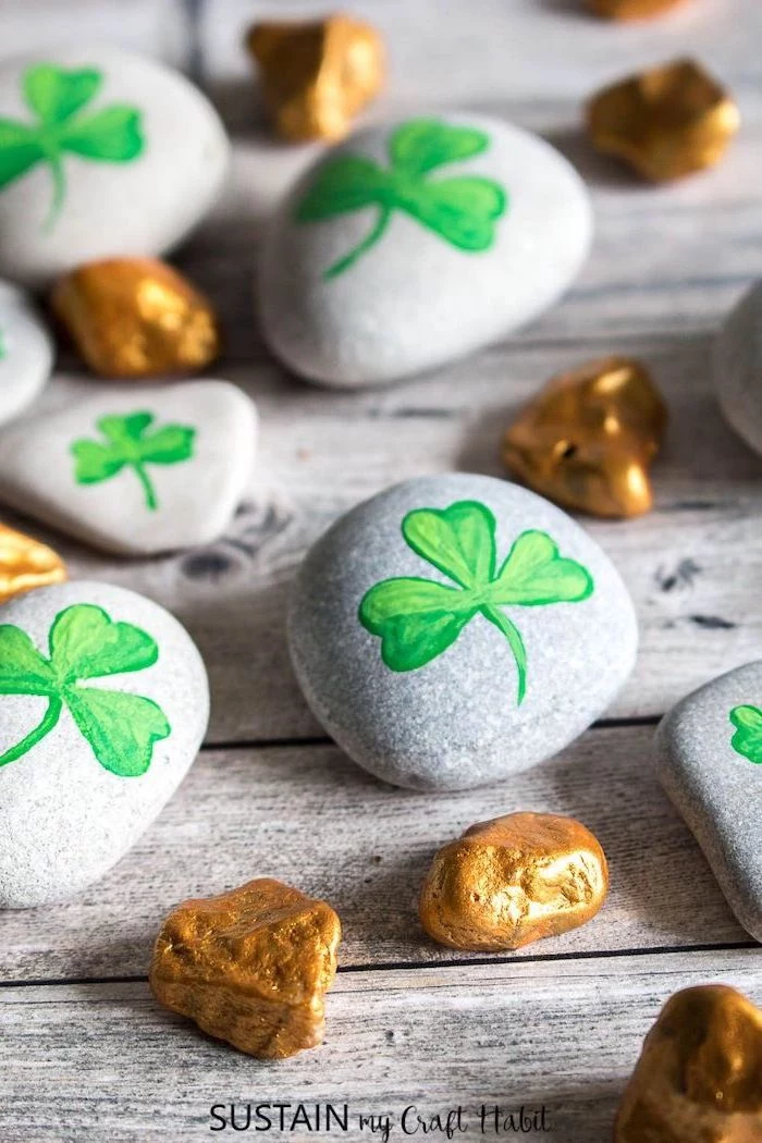 small rocks painted in gold, bigger rocks with green shamrocks painted on them, st patrick's day party ideas