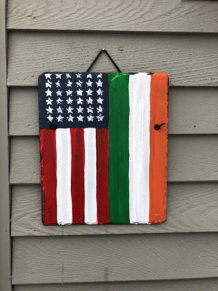 stone board with the usa and irish flags, painted on it, st patricks day games, hanging on grey wooden wall
