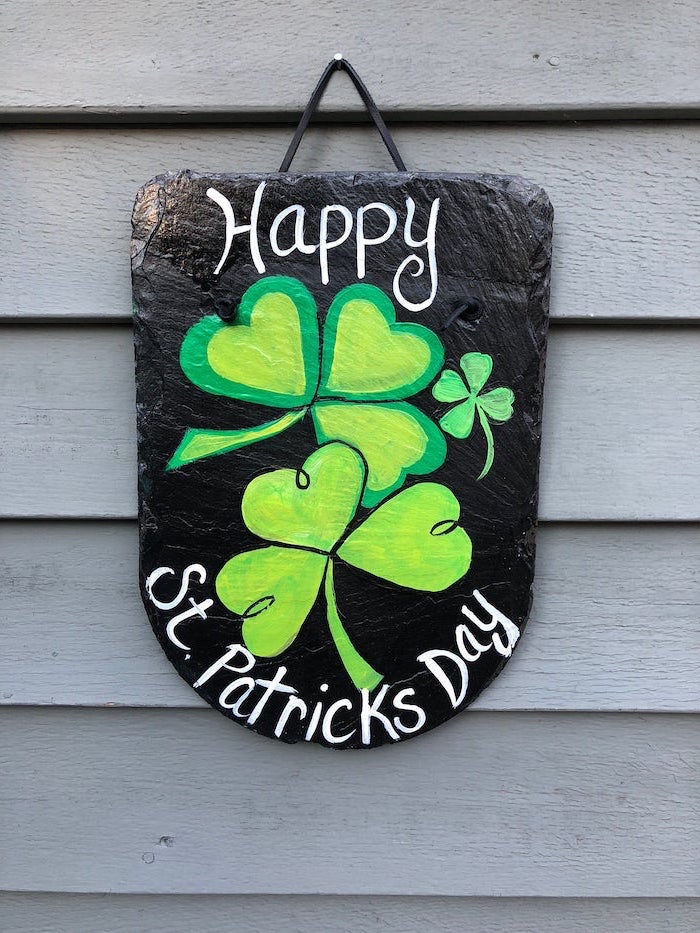 stone board, hanging on wooden wall, st patricks day crafts, two shamrocks painted on it