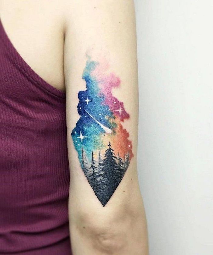watercolor back of arm tattoo, shooting star above tall trees, galaxy tattoo ideas, orange blue and pink galaxy sky