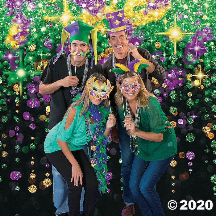 two men and two women posing for a photograph, mens mardi gras masks, wearing different masks in purple gold and green