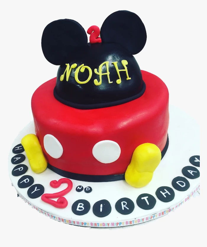 one tier cake, covered with black and red fondant, placed on white cake tray, mickey mouse cake pan