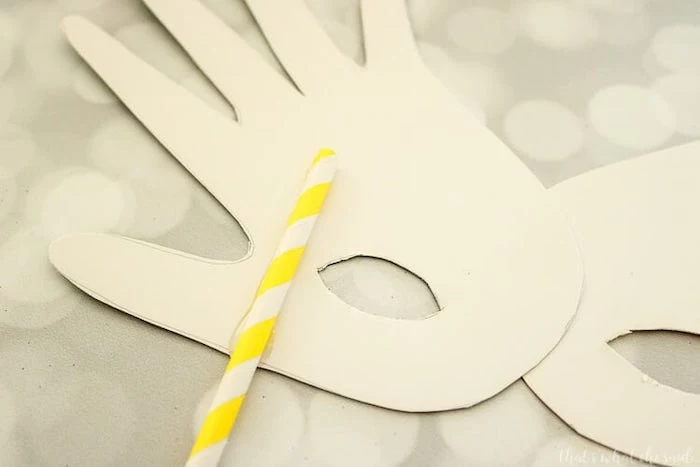 paper cut out of a handprint, masquerade masks for women, yellow and white paper straw, glued to the paper