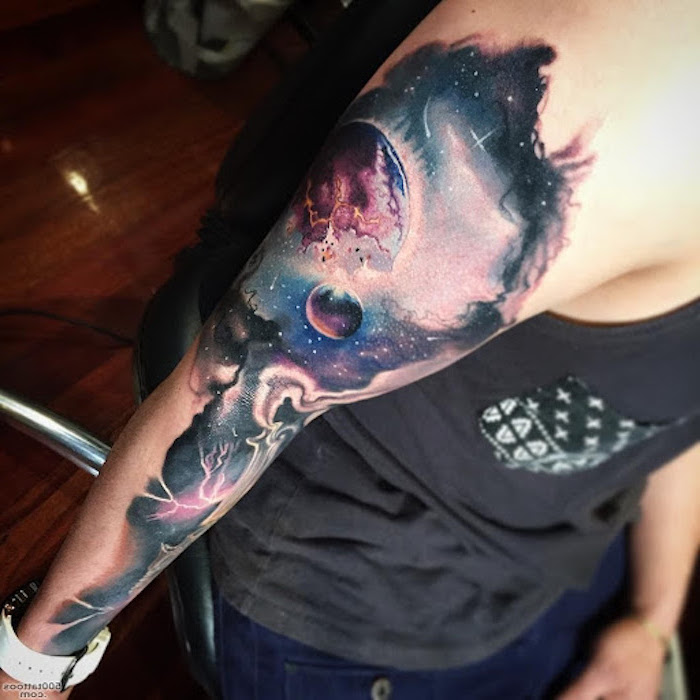 sleeve tattoo of galaxy, milky way tattoo, planets and stars inside the galaxy, man wearing black top